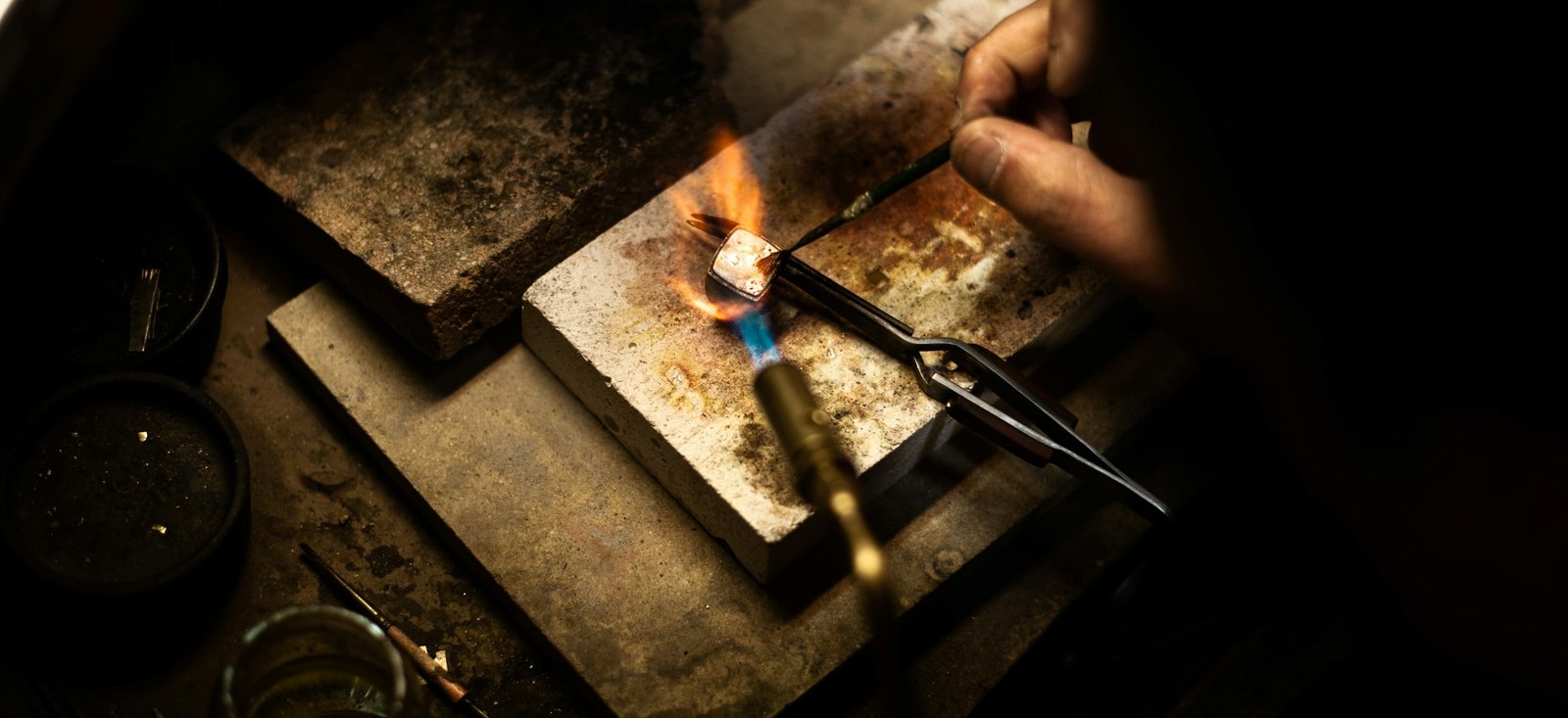 Flamme de chalumeau sur un bloc de brasure, dans l’atelier