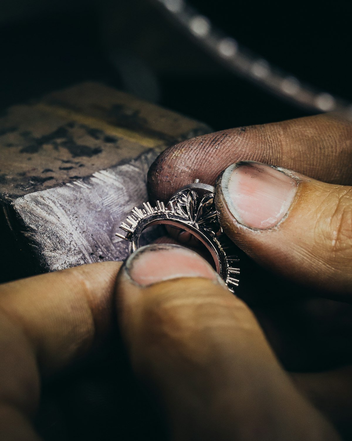 Doigts tenant une bague en cours de fabrication
