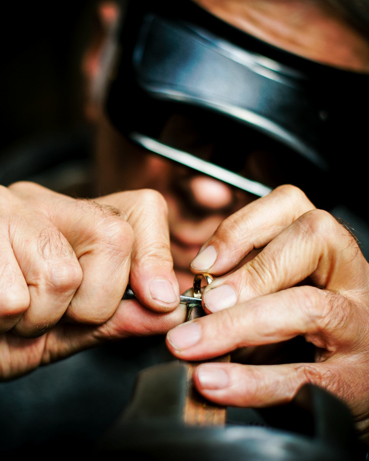 Mains ajustant une bague sous une loupe d’atelier